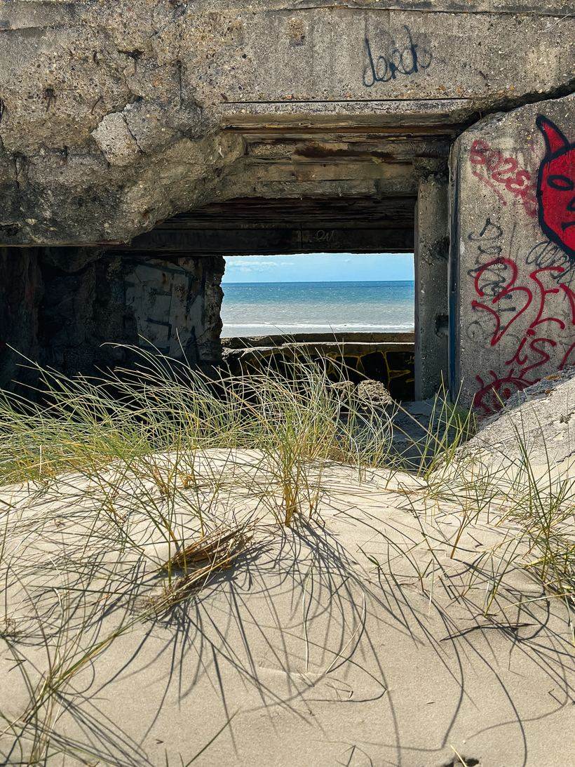 La mer encadrée par l'ouverture d'un blockhaus envahi par les oyats, sur la plage de Fort-Mahon